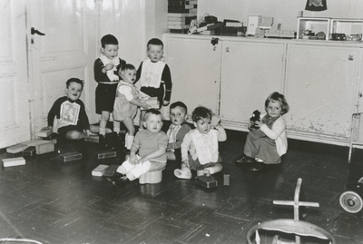 876978 Afbeelding van een groep kleuters met speelgoed in een zaaltje in het opvanghuis 'Meisjesstad' (Oudegracht 35) ...